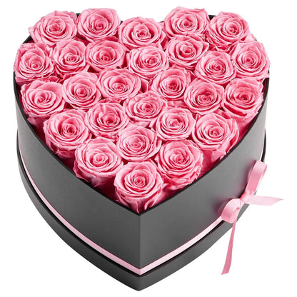 Heart-shaped box filled with pink roses on a white background