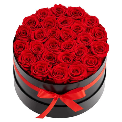 Round black box filled with red roses and a red ribbon on a white background